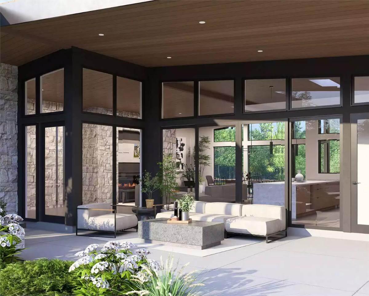 Relax in This Inviting Patio with Sleek Seating and Expansive Glass Walls