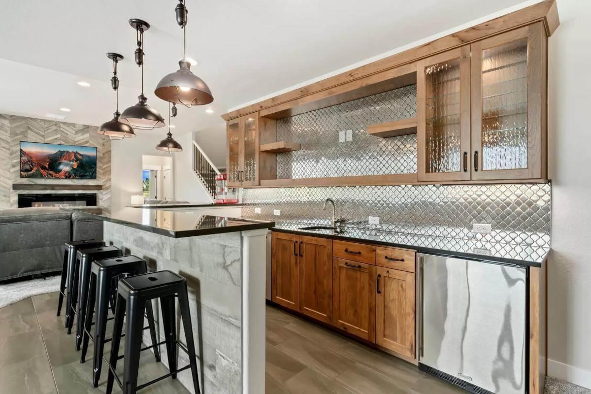 Check Out the Industrial Pendant Lighting and Textured Backsplash in This Bar Area
