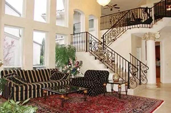 Elegant Living Room with Curved Staircase and Dramatic Windows