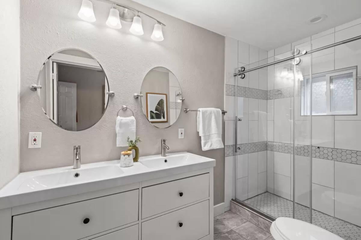 Dual Oval Mirrors and Sleek Fixtures in This Modern Bath