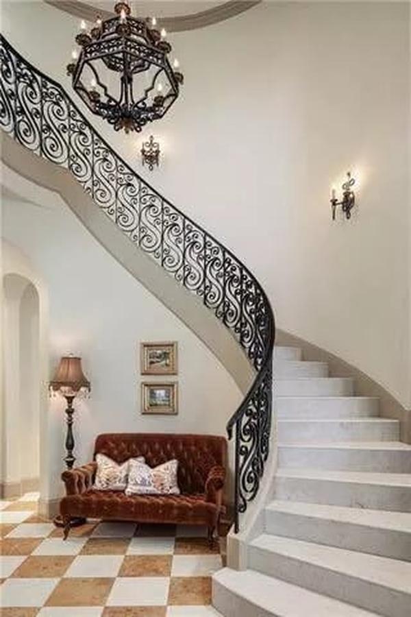 Spiral Elegance: A Grand Staircase with Wrought-Iron Detail