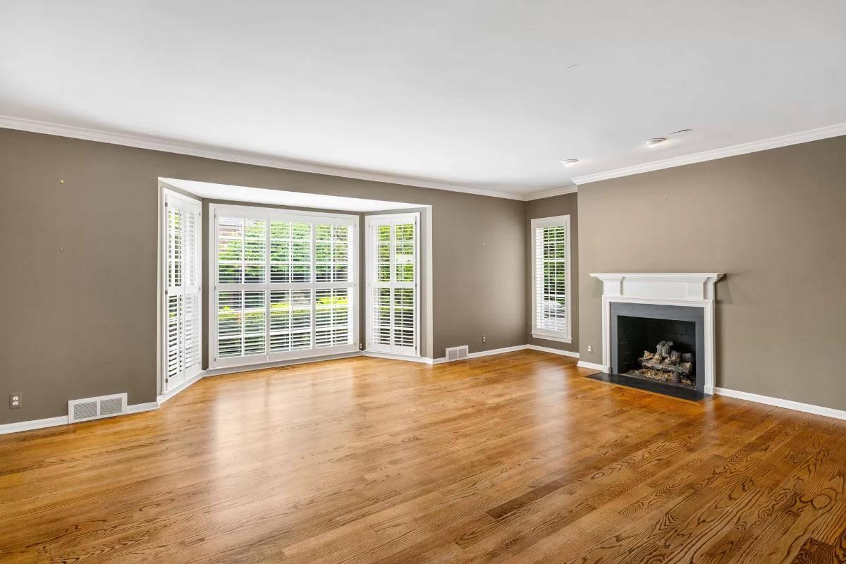 Check Out This Living Room with a Bay Window and Classic Fireplace