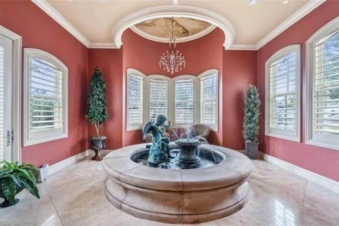 Elegant Conservatory with a Central Fountain and Rich Red Walls