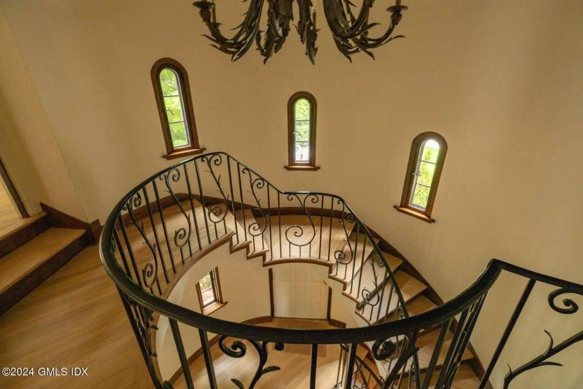 Explore the Graceful Curves of This Staircase with Wrought Iron Details
