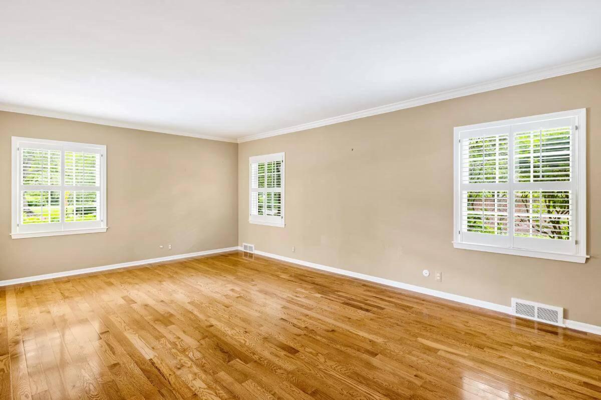 Notice the Crisp White Shutters and Polished Hardwood in This Open Room