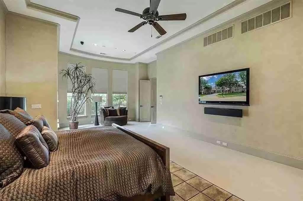 Bedroom Retreat with Wall-Mounted TV and Accent Ceiling Fan