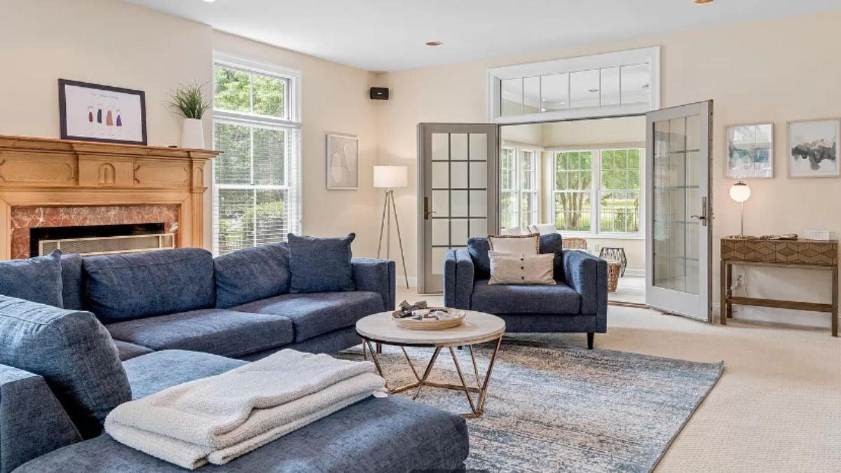 Inviting Living Room with a Charming Wooden Mantel and Cozy Blue Sofas
