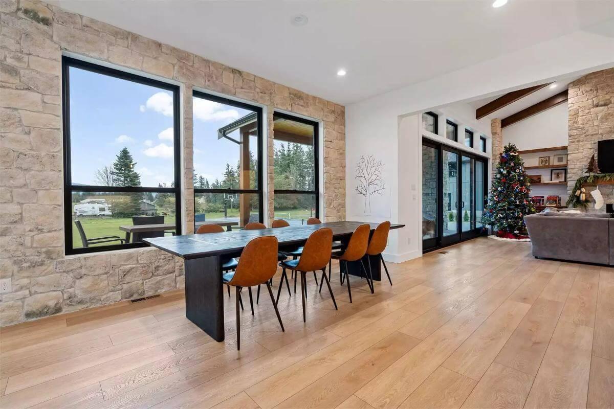 Dining Room with Expansive Windows and Stone Wall Highlight