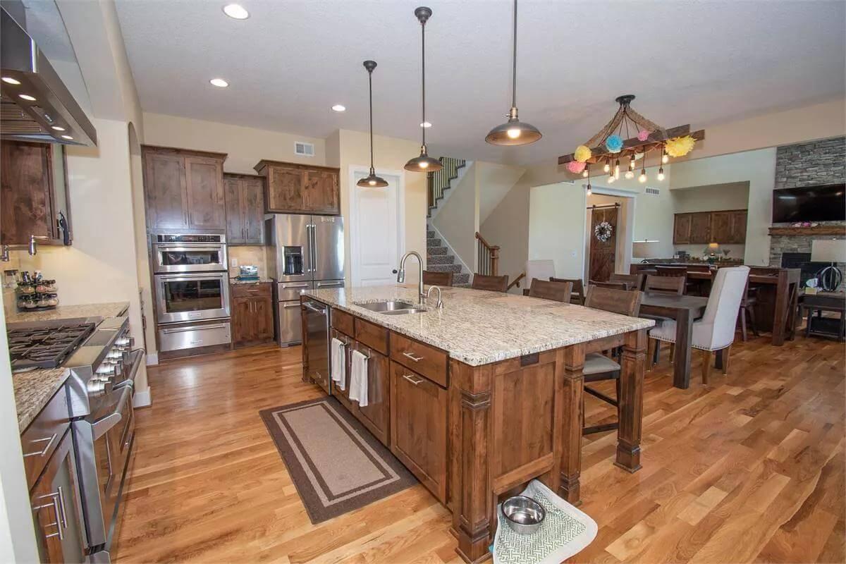 Notice the Expansive Island and Earthy Pendant Lighting in This Kitchen