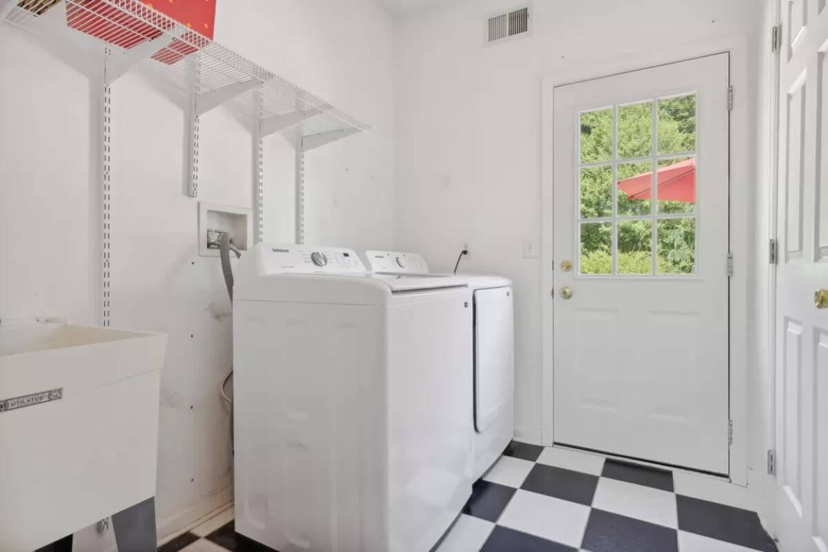 Crisp Laundry Room with Classic Checkered Floors and Garden View Door