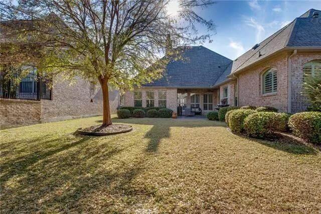 Embrace Outdoor Serenity in This Spacious Backyard with Brick Detailing