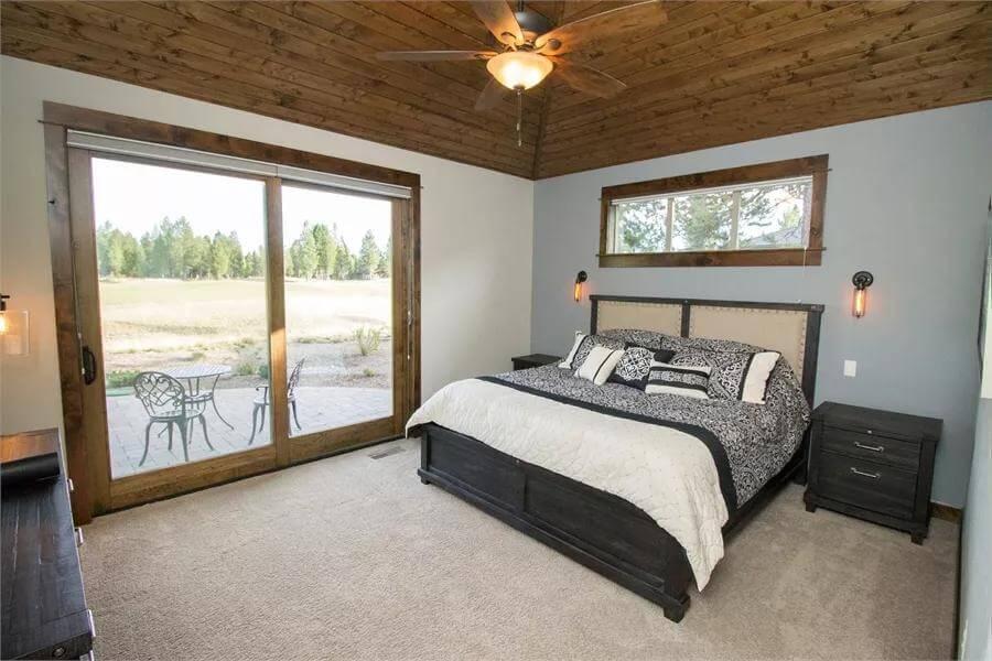 Relax in This Craftsman Bedroom with Ceiling Detail and Patio Access