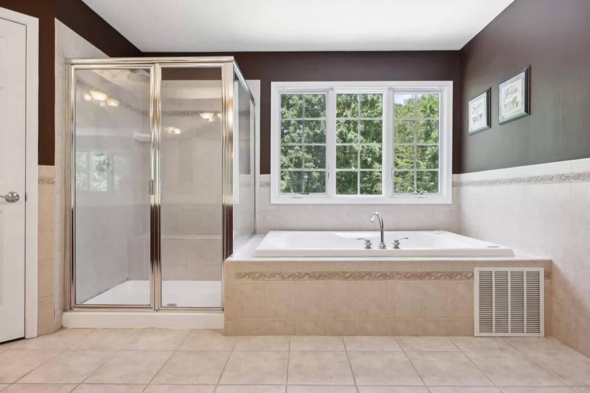 Elegant Bathroom with Sunlit Tub and Glass-Enclosed Shower