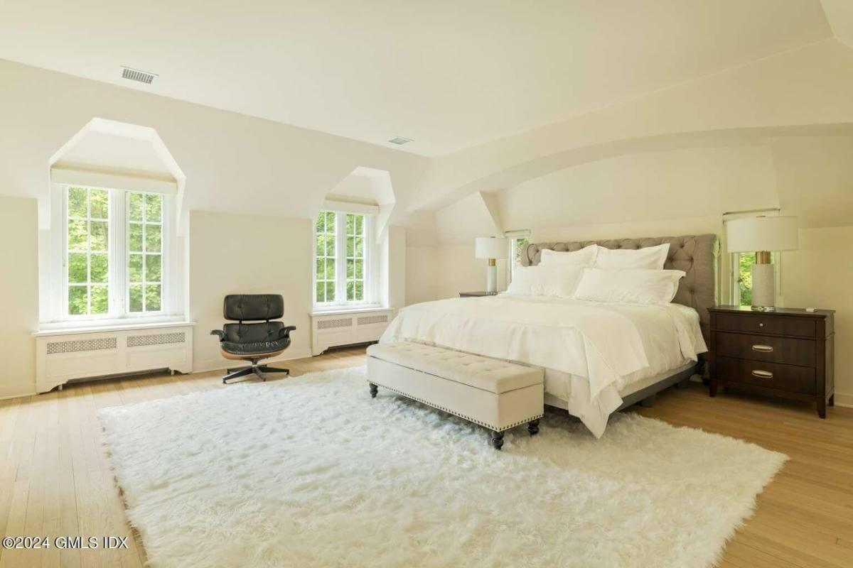 Unwind in This Bedroom with Luxurious Carpeting and Cozy Seating