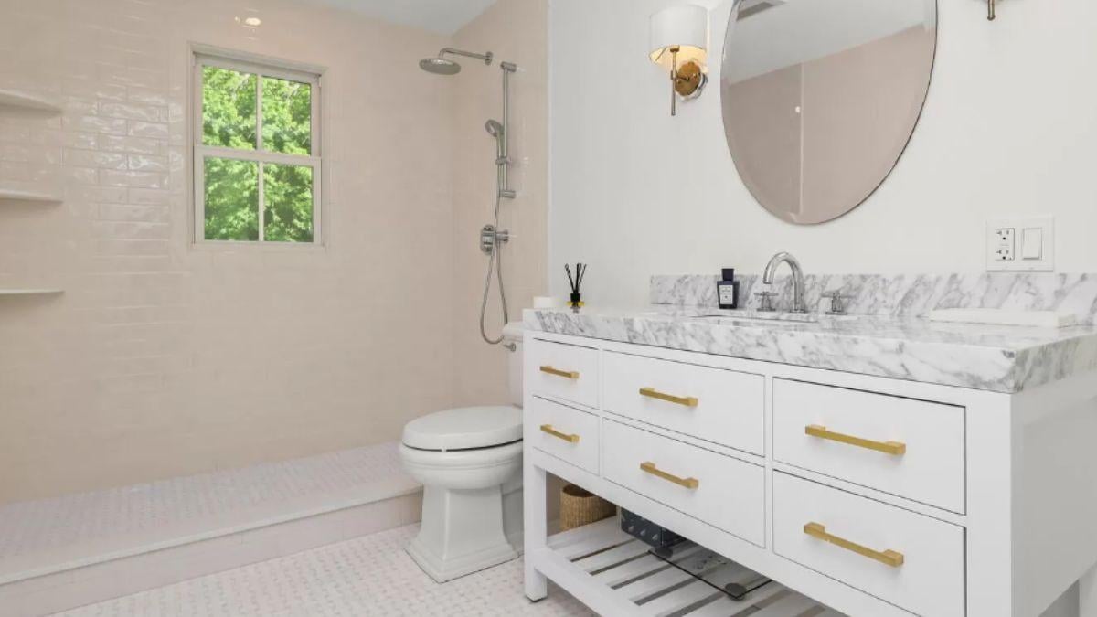 Notice the Elegant Brass Accents in This Bright Bathroom