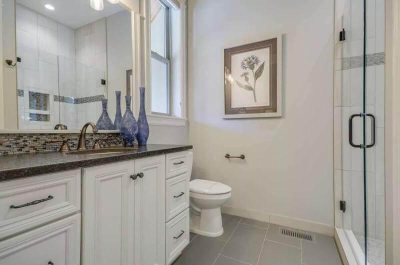 Explore the Elegant Blend of White Cabinetry and Mosaic Tiles in This Craftsman Bathroom
