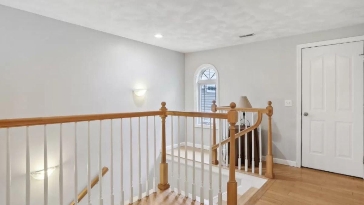Notice the Classic Wood Trim on This Airy Stairway Landing