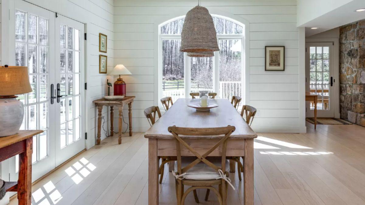Sunlit Dining Room with Rustic Wood Table and Inviting Views