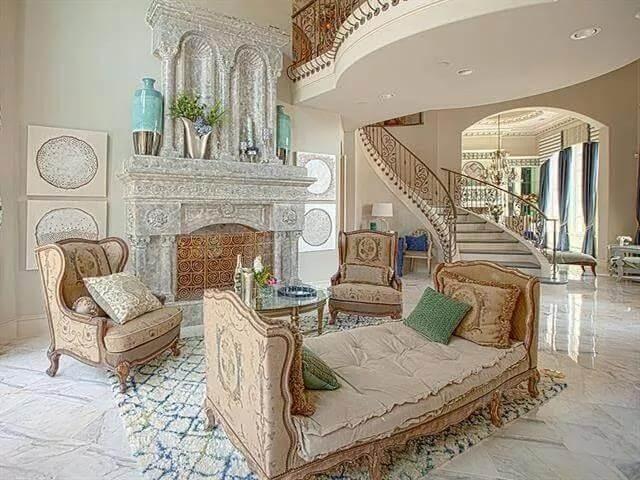 Elegant Living Room with Ornate Fireplace and Curved Staircase