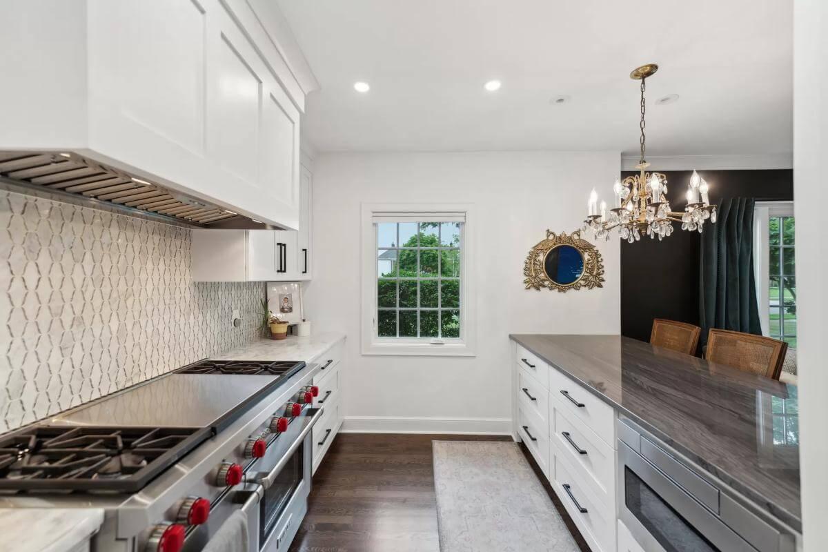 Elegant Kitchen with Marble Backsplash and Shimmering Chandelier