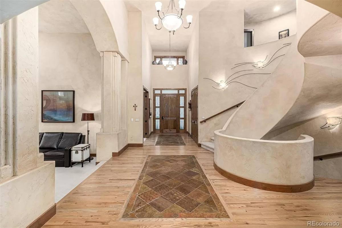 Elegant Craftsmanship in a Sunlit Foyer with Curved Staircase