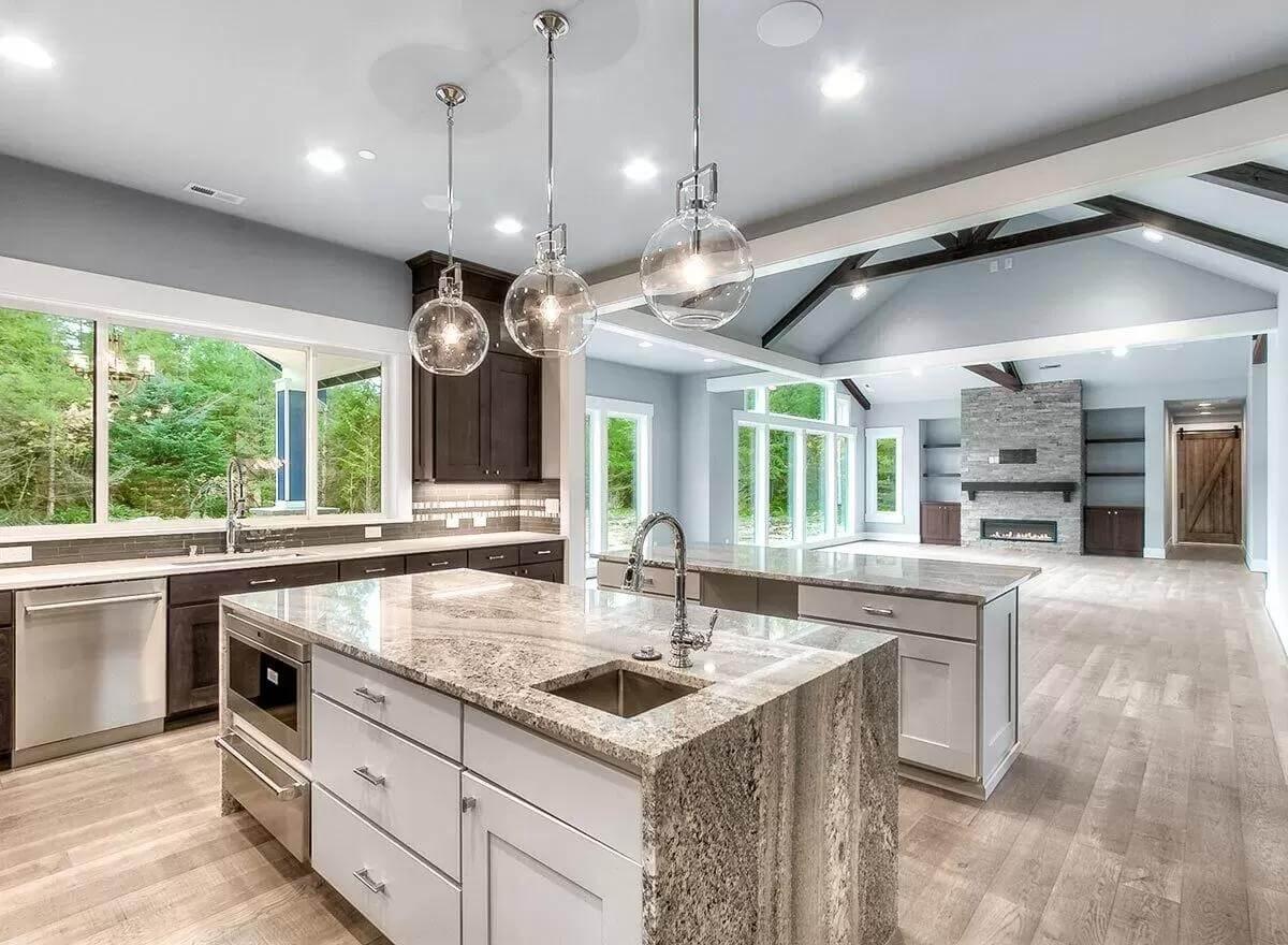 Admire the Sleek Granite Island Accompanied by Striking Globe Pendants