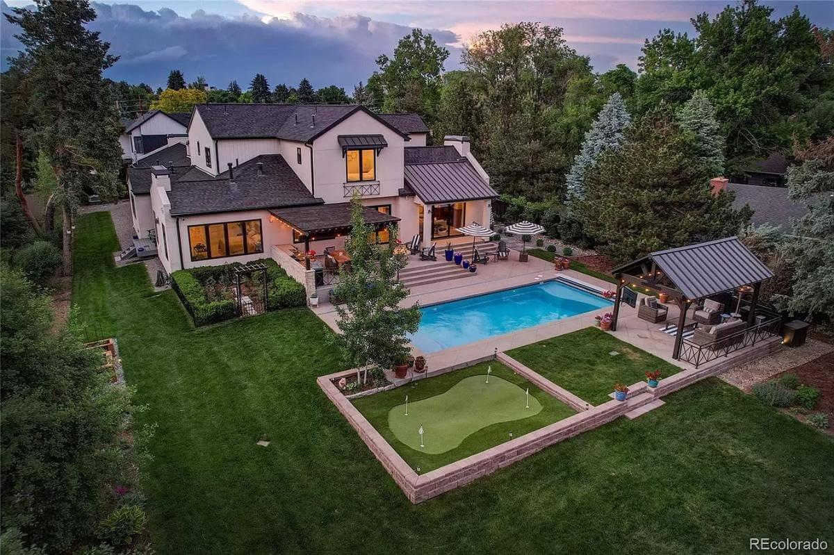 Enjoy This Stunning Backyard with a Poolside Lounge and Putting Green