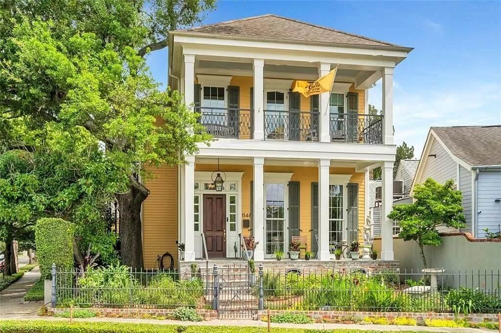 Charming Southern Porch with Classic Columns and a Cheerful Yellow Facade