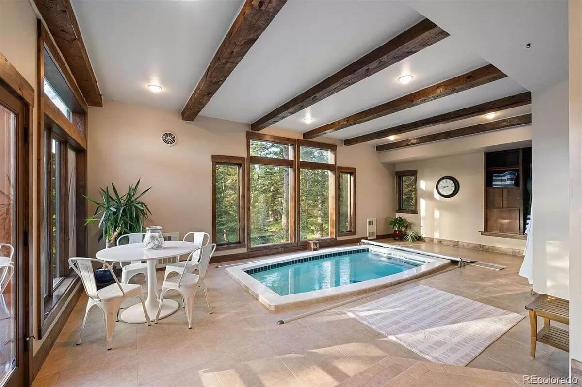 Indoor Pool Oasis with Exposed Beams and Forest Views