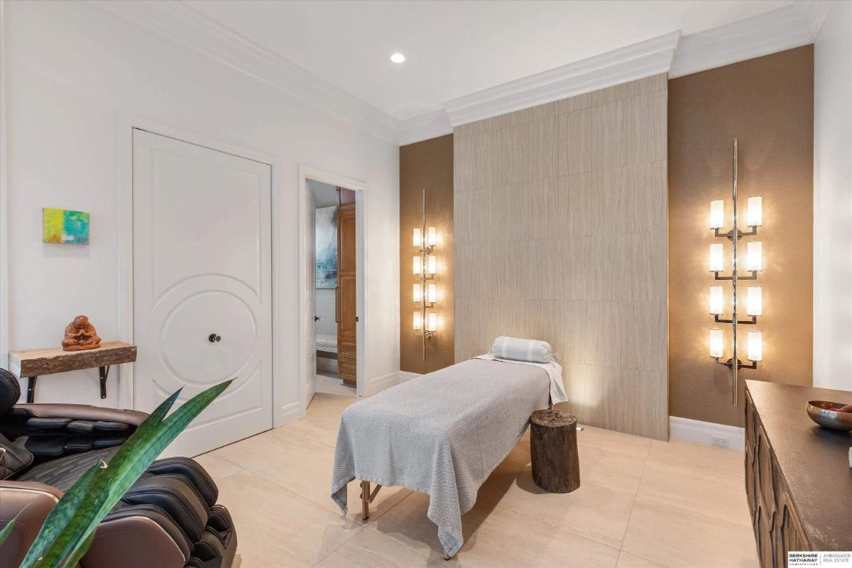 Massage room with treatment table, wall sconces, and soft ambient lighting. 
