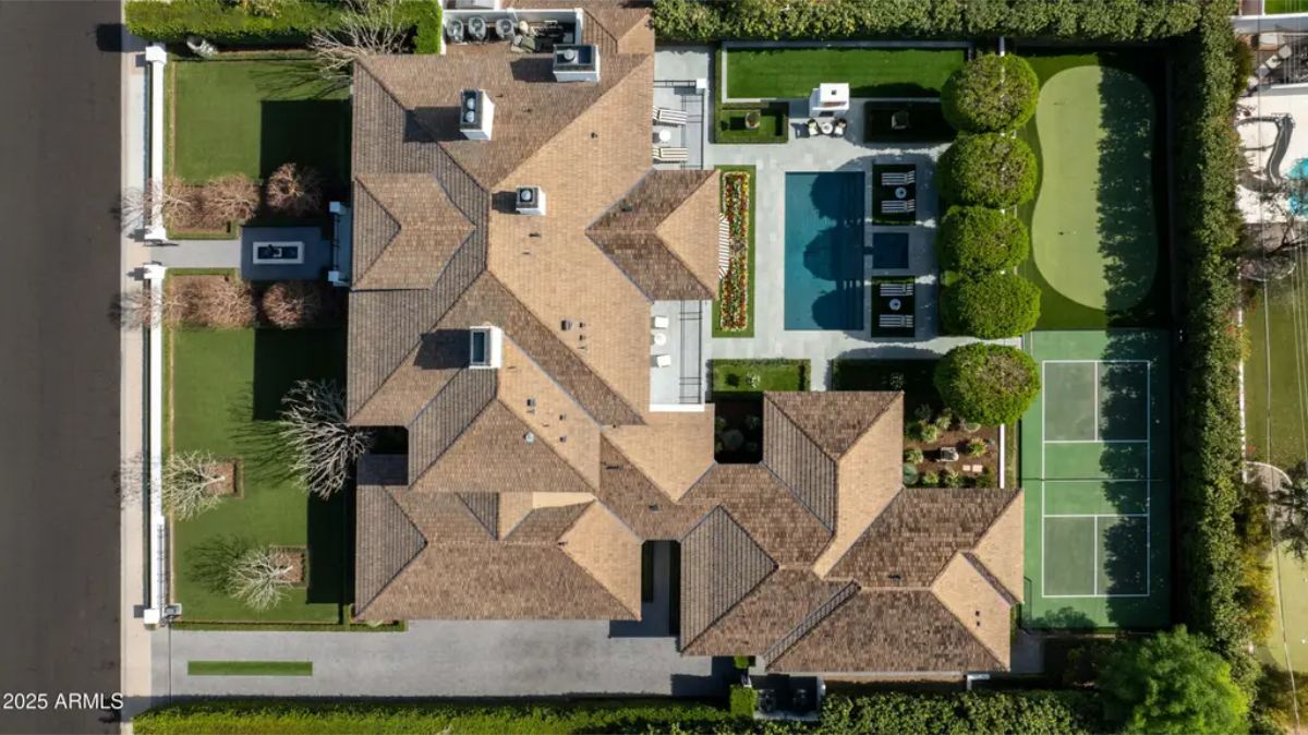 Overhead view of estate showing main residence, central pool area, tennis court, and surrounding landscaping.