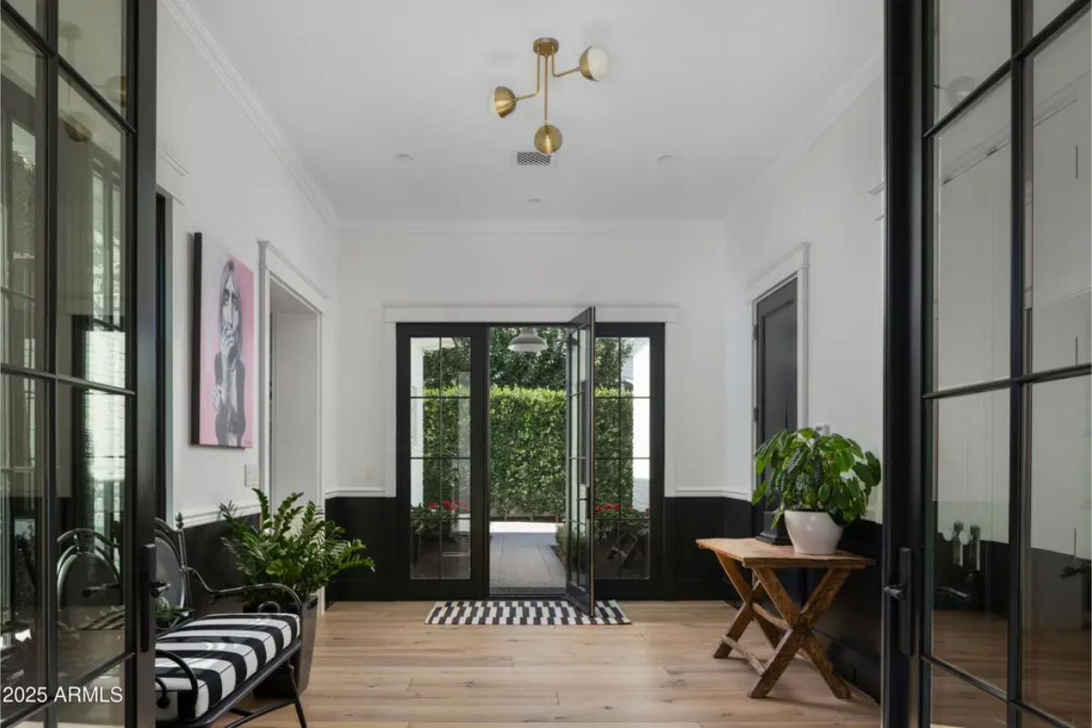Entry sitting area with glass doors, striped rug, and black-trimmed walls.