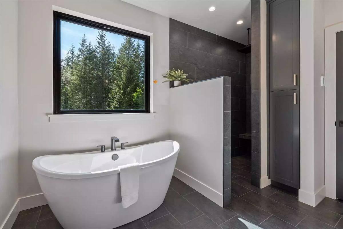 Freestanding Tub with a Forest View in a Sleek Bathroom