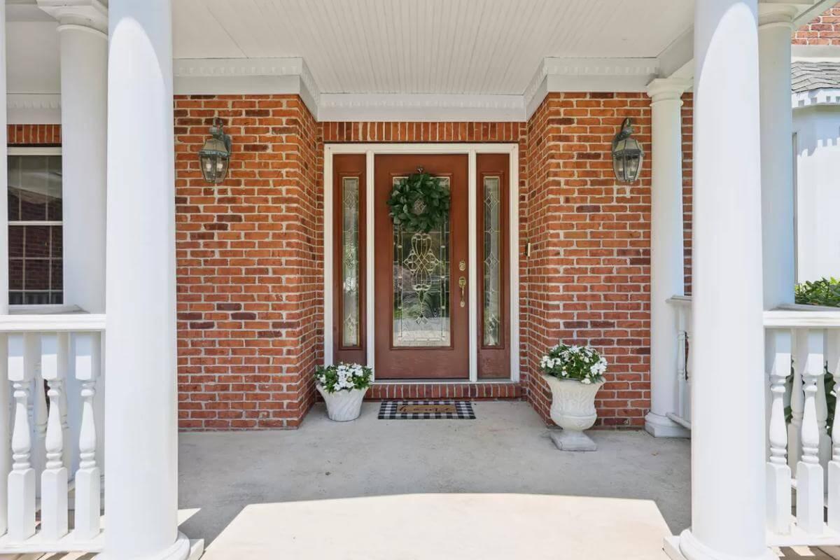Welcoming Front Porch with Elegant Glass Door and Stately Columns