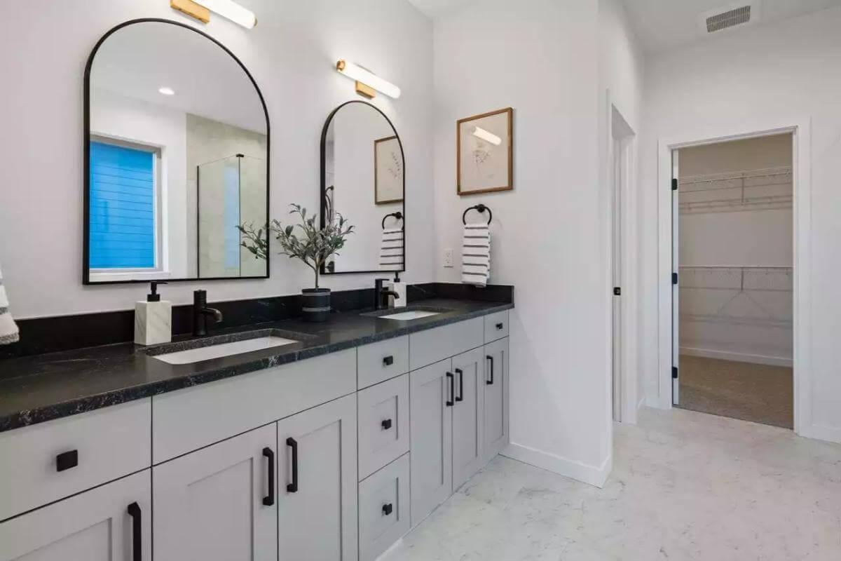 Double Vanity Elegance with Arched Mirrors and Black Accents