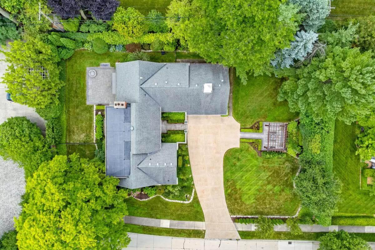 Aerial View Showcasing Lush Landscaping and Spacious Driveway