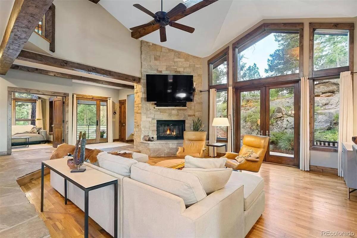 Grand Living Room with Stone Fireplace and Forest Views