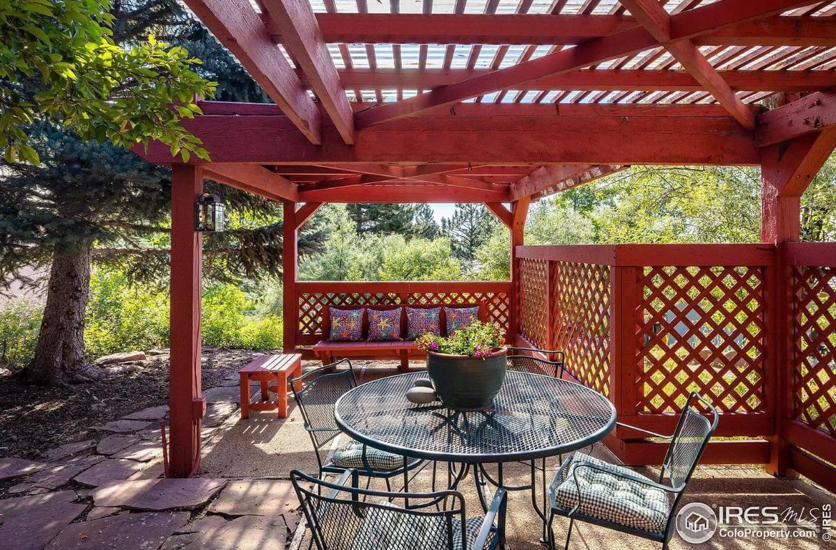 Enjoy This Vibrant Pergola Patio With a Splash of Red