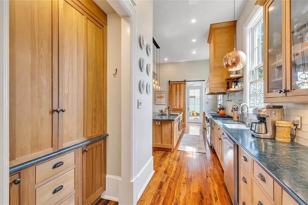 Notice the Sleek Countertops in This Warm Galley Kitchen