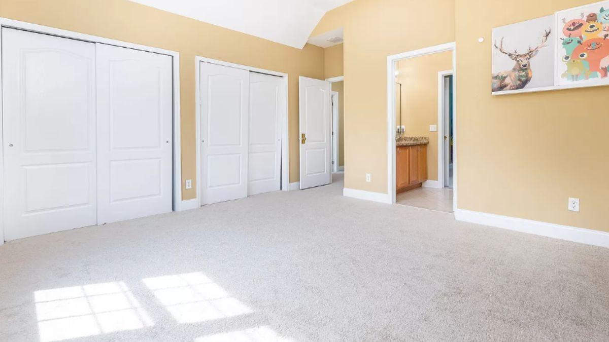 A Spacious Room with Soft Yellow Walls and Built-In Closets