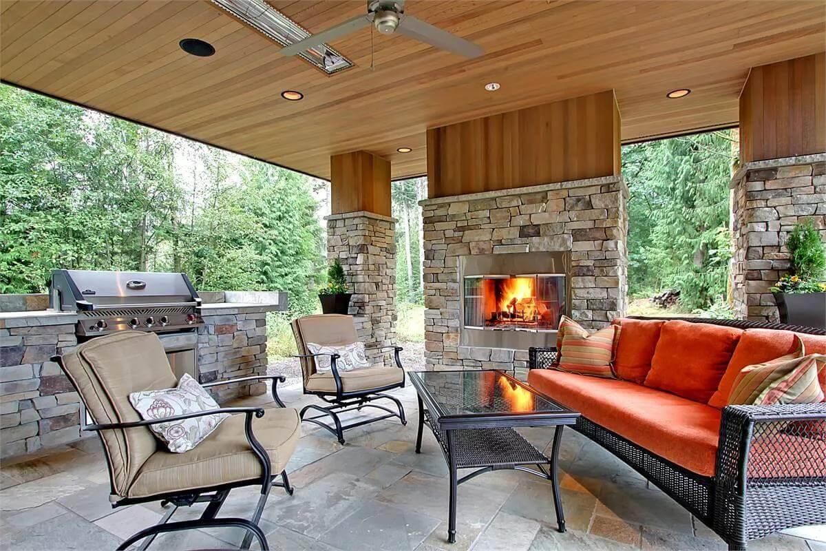 An Inviting Outdoor Haven with a Stone Fireplace and Ceiling Fans