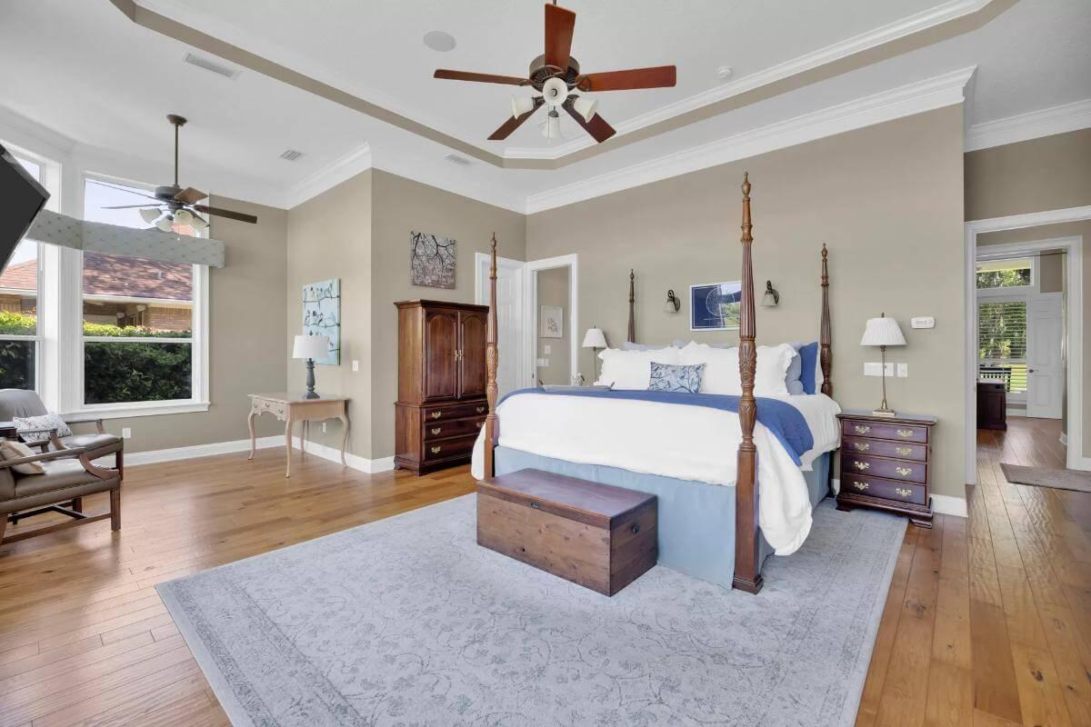 Check Out This Relaxing Primary Suite with a Four-Poster Bed and Elegant Tray Ceiling