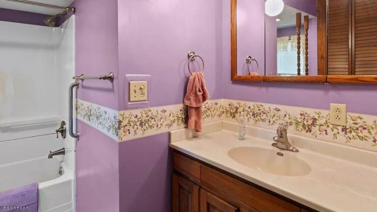 Retro Bath Delight with Floral Trim and Bold Lavender Walls