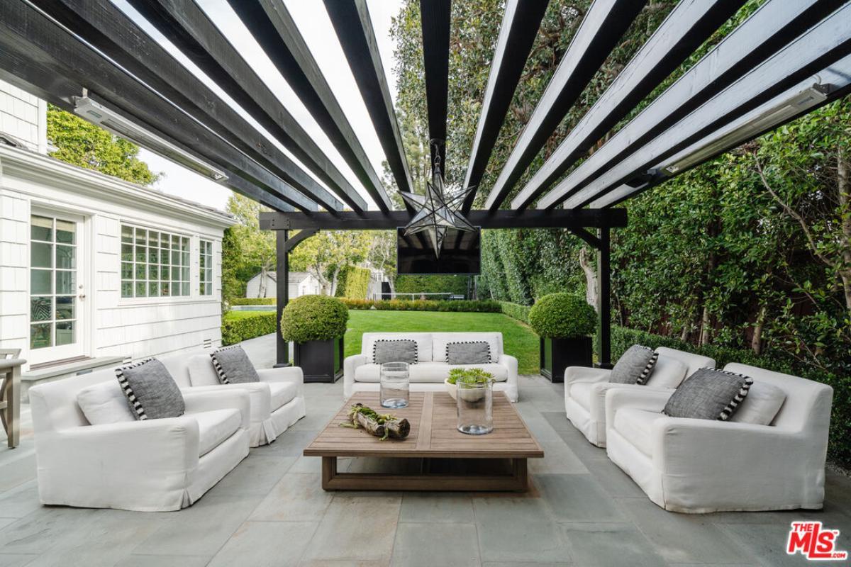 Modern Outdoor Lounge with Striking Pergola and Lush Greenery