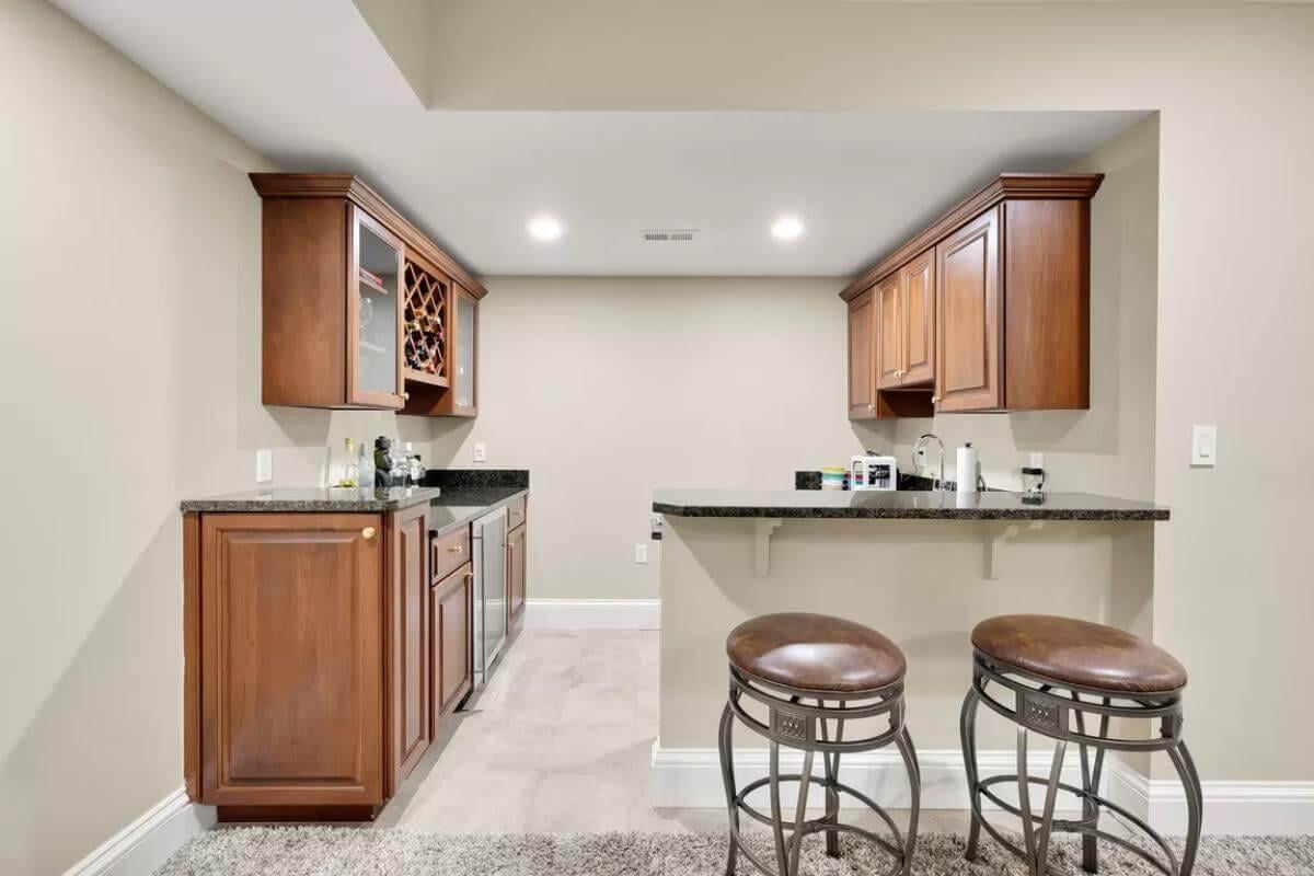 Compact Basement Bar with Rich Wood and Sleek Countertops
