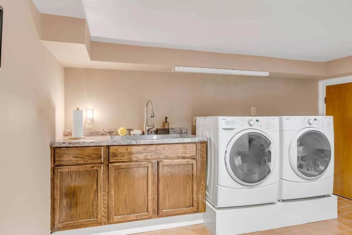 Compact Laundry Area with Practical Sink and Oak Cabinets