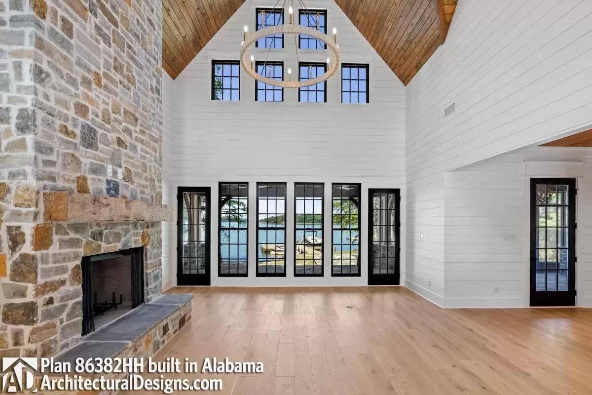 Notice the Soaring Ceiling and Stone Fireplace in This Lake View Living Room