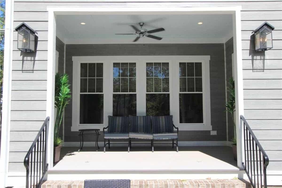Charming Front Porch with Dual Lanterns and Fan for Comfort