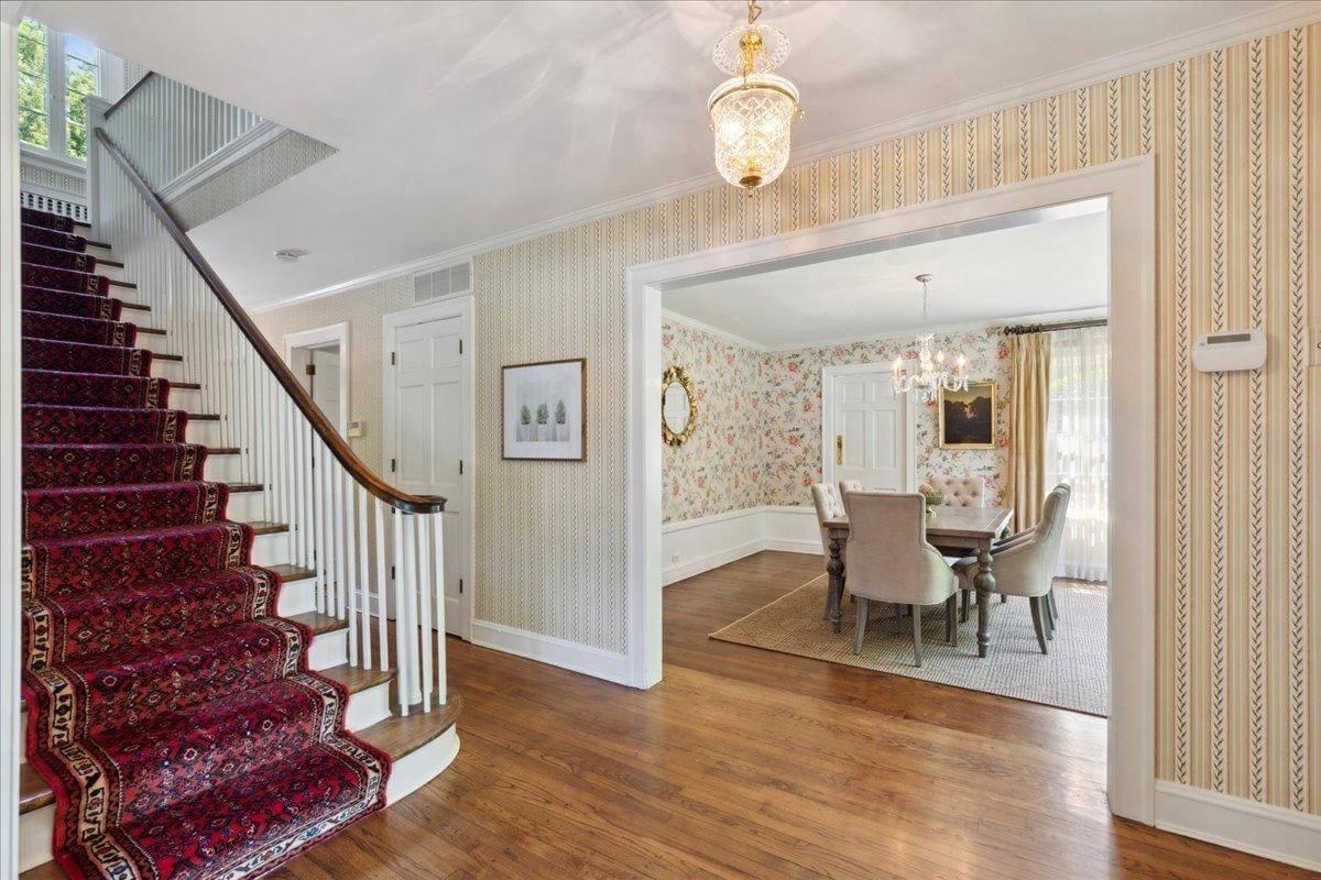 Charming Entryway with Floral Wallpaper and a Curved Staircase