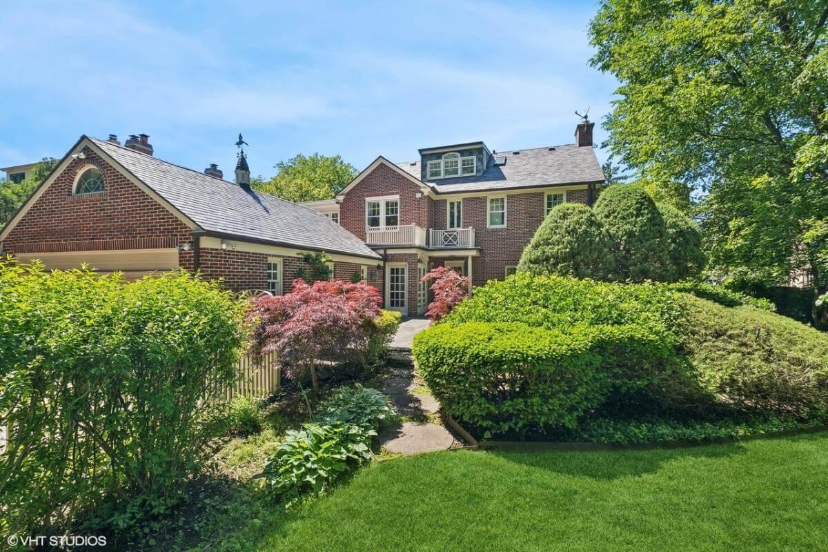 Brick Elegance with Classic Dormer Windows and Lush Gardens